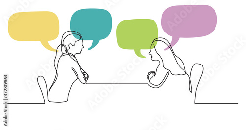 two young women sitting behind table talking with speech bubbles photo