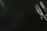 lay out antique expensive silver cutlery. knife, fork on the table .  to shine in light. Top view photo of black background with copy space.