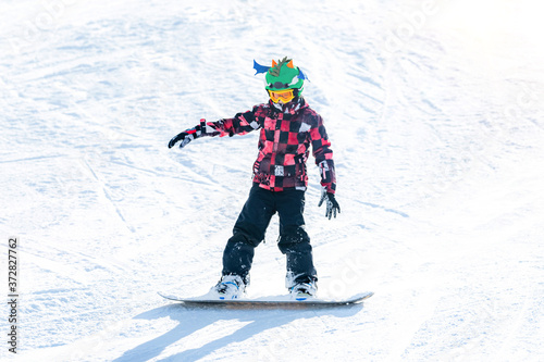 Cute Boy Having Fun, Snowboarding in the Mountains