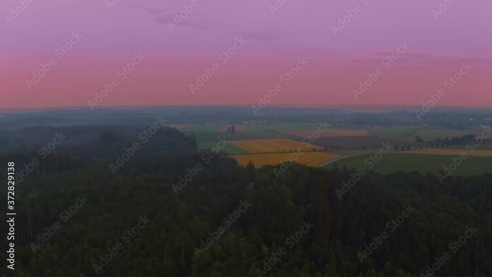 Wonderful violet morning sky, flight by a drone over a forest forward to a yellow field of grain. Wonderful violet morning sky, flight by a drone over a forest forward to a yellow field of grain.