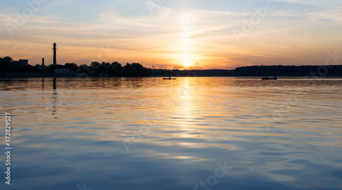 Kayak and boat in the distance at sunset on Lake Senezh, city of Solnechnogorsk, Russia