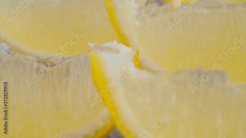 Extreme close up lemon cutted into wedges. Macro shot of citrus. Healthy lifestyle concept. Camera slowly moving on slider