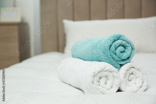 Soft clean towels on bed at home