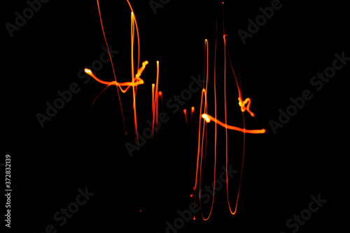 Creative Conceptual Fine Art Photography Motion Blur Sparkle Light Trail On Dark Background Copy Space For Text. Artistic design by lamp fire flame line at night slow shutter speed of camera exposure.