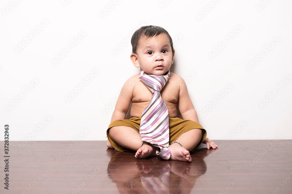 Baby in-front of white wall playing with red pillow. Baby in-front of white wall playing with red pillow.