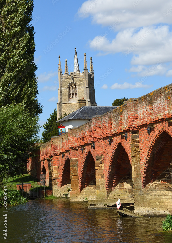 Great Barford Packhorse Bridge and All Saints Church Tower. Bedfordshire England. Great Barford Packhorse Bridge and All Saints Church Tower. Bedfordshire England.