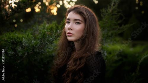 Portrait of a beautiful young girl in the forest at sunset © kulichok