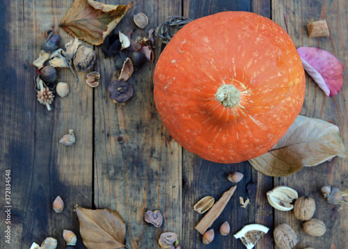 orange squash in autumnal background on wooden table