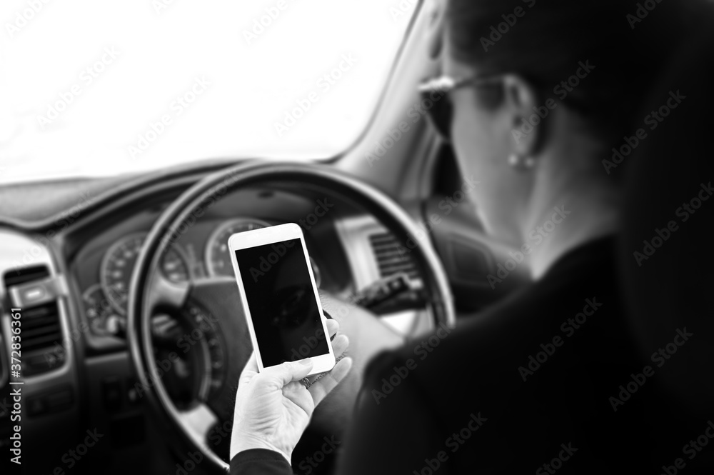 Woman using mobile phone while driving a car Woman using mobile phone while driving a car