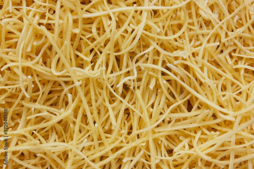 Small layer of dry noodles. The food background is a pasta texture. Homemade noodles. Cooking. Background. Texture. View from above. Cooking. Copy space for text Small layer of dry noodles. The food background is a pasta texture. Homemade noodles. Cooking. Background. Texture. View from above. Cooking. Copy space for text