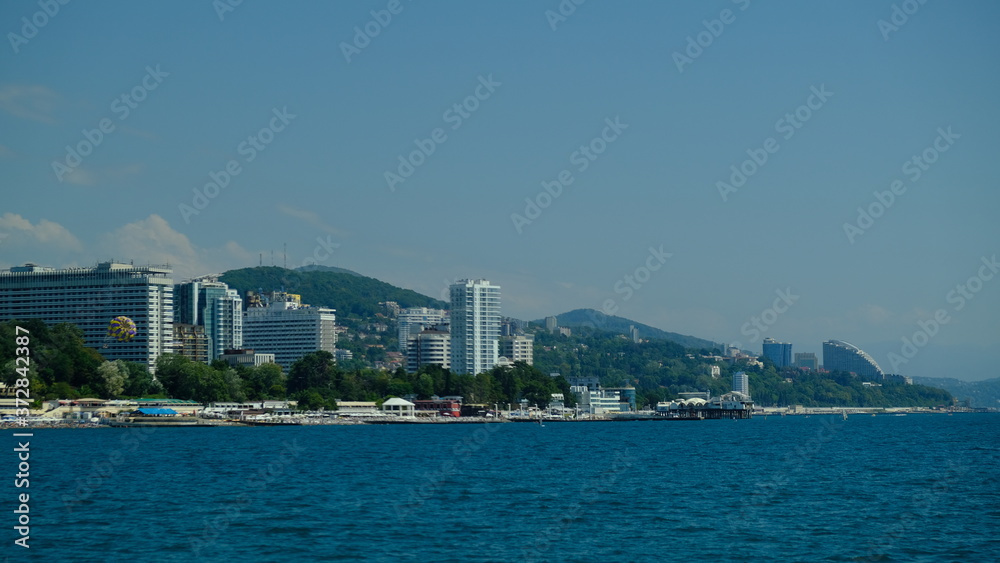 Panorama of the coast of Sochi in summer. Large-format. Black Sea, Russia. View from the sea. No people. Sunny day. Modern city on the beach.