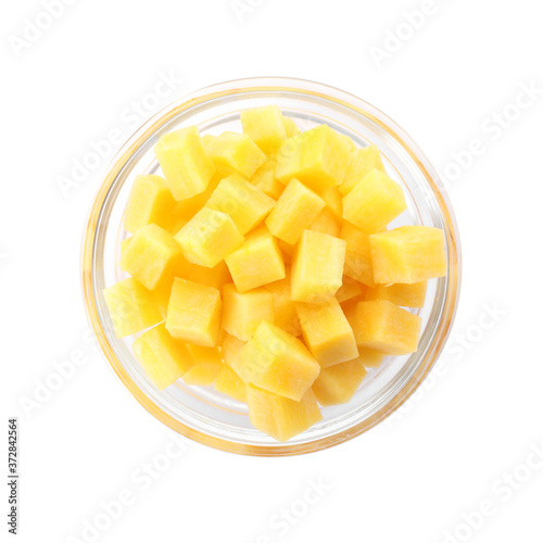 Raw yellow carrot cubes in glass bowl isolated on white, top view