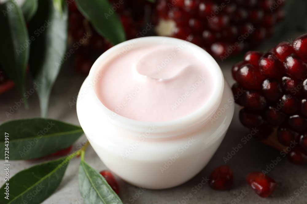 Natural facial mask, pomegranate seeds and green leaves on light grey table, closeup Natural facial mask, pomegranate seeds and green leaves on light grey table, closeup