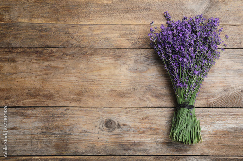 Beautiful lavender bouquet on wooden background  top view. Space for text