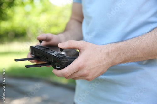 Man holding new modern drone controller outdoors, closeup of hands