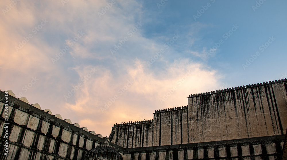 The fort walls of The Kumbhalgarh Fort. Beautiful evening blue sky with clouds.  