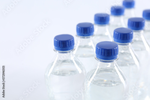 Plastic bottles with pure water on white background, closeup