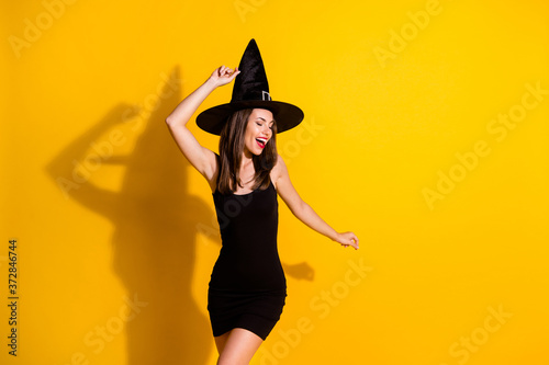Portrait of her she nice-looking attractive pretty lovely cheerful cheery ecstatic lady wizard wearing cone hat dancing having fun isolated on bright vivid shine vibrant yellow color background
