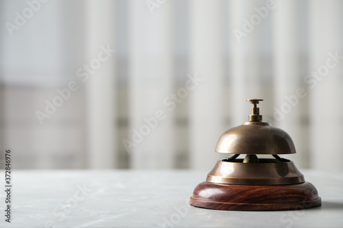 Hotel service bell on table indoors, closeup. Space for text