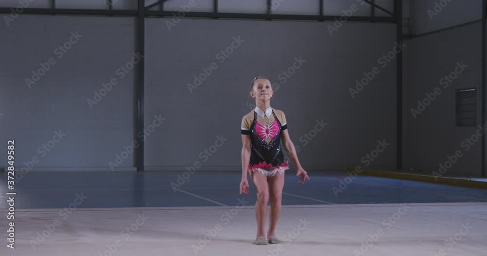 Teenage female gymnast performing at sports hall Teenage female gymnast performing at sports hall