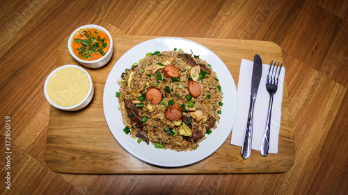 Peruvian food arroz chaufa, plate of fried rice with vegetables and different meats. photo