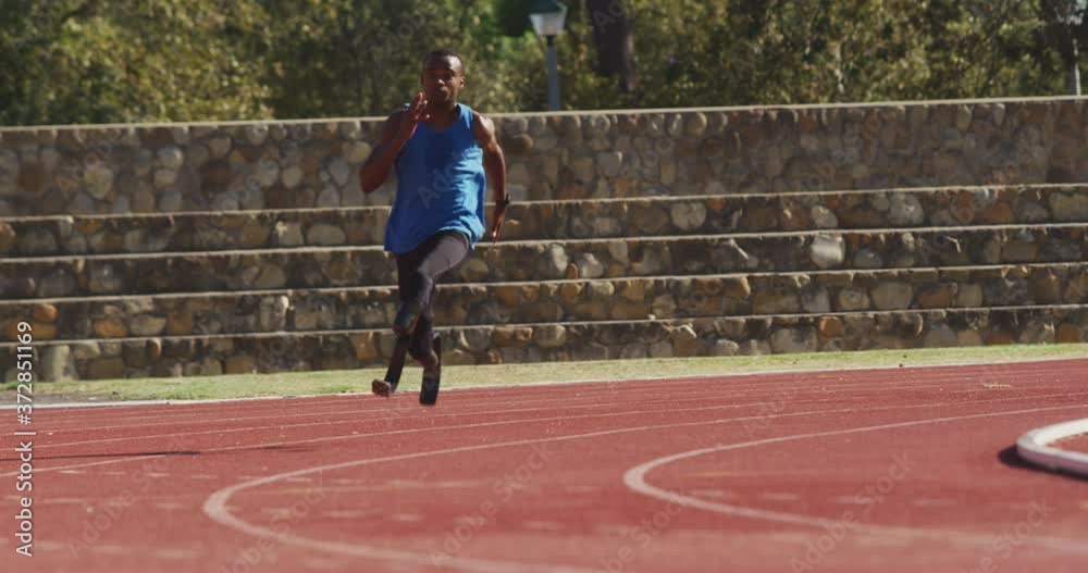 Disabled mixed race man with prosthetic legs running on race track Disabled mixed race man with prosthetic legs running on race track