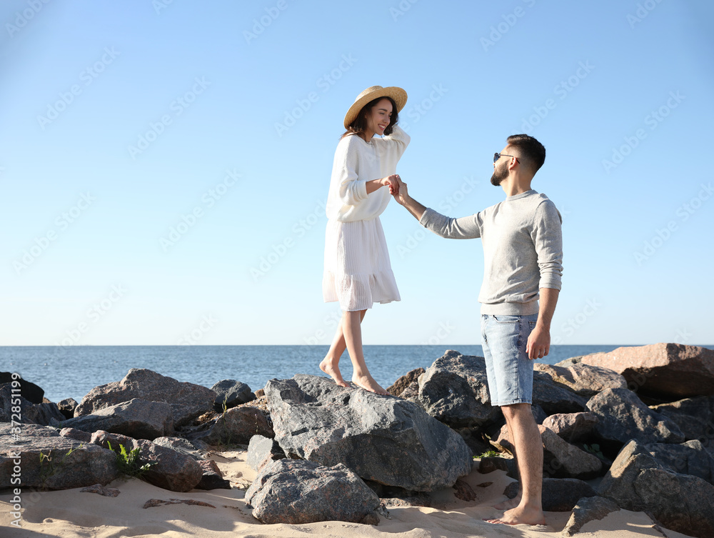 Happy young couple walking at beach. Honeymoon trip
