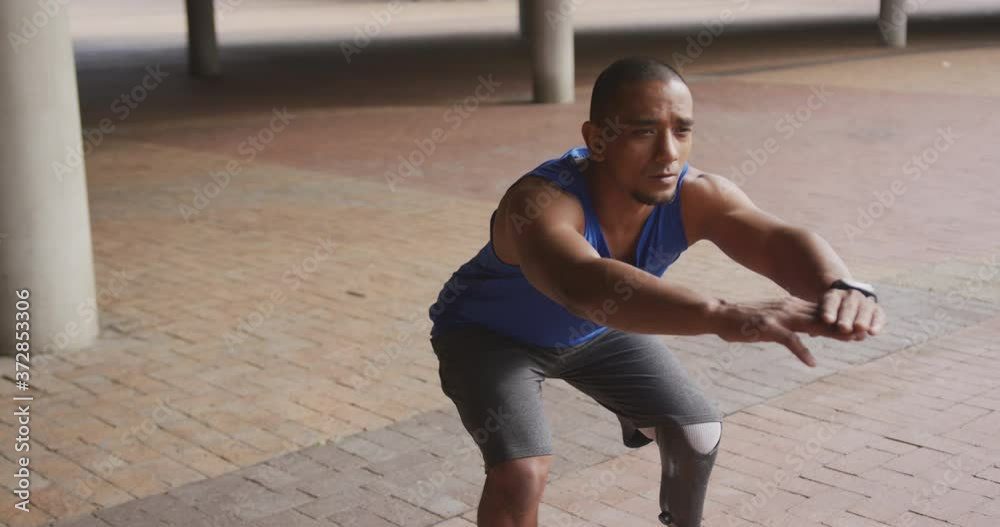 Side view man with prosthetic leg doing squats Side view man with prosthetic leg doing squats