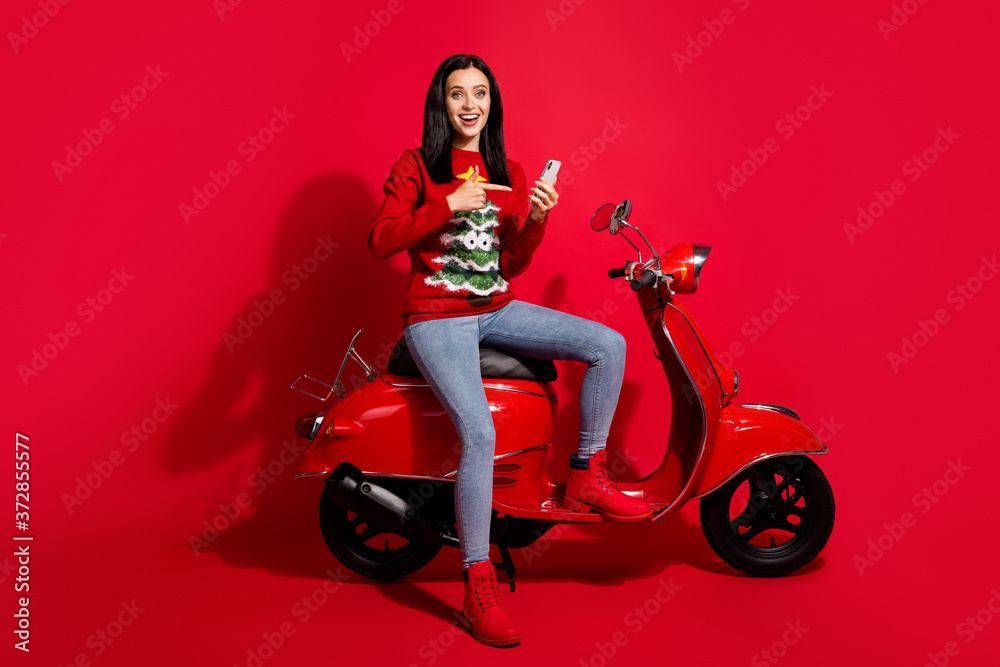 Portrait of her she nice attractive glad cheerful cheery girl sitting bike using device gadget app demonstrating sale fast speed 5g isolated over bright vivid shine vibrant red color background Portrait of her she nice attractive glad cheerful cheery girl sitting bike using device gadget app demonstrating sale fast speed 5g isolated over bright vivid shine vibrant red color background