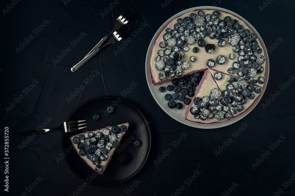 Cottage cheese casserole decorated with blackberry and blueberry on dark textured background. Flat lay. Copy space.