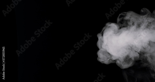 plume of thick smoke flowing in against a black background.