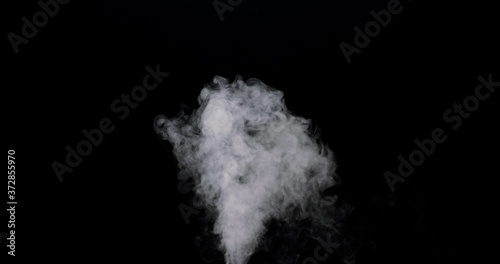 plume of smoke bubbling up against a black background.