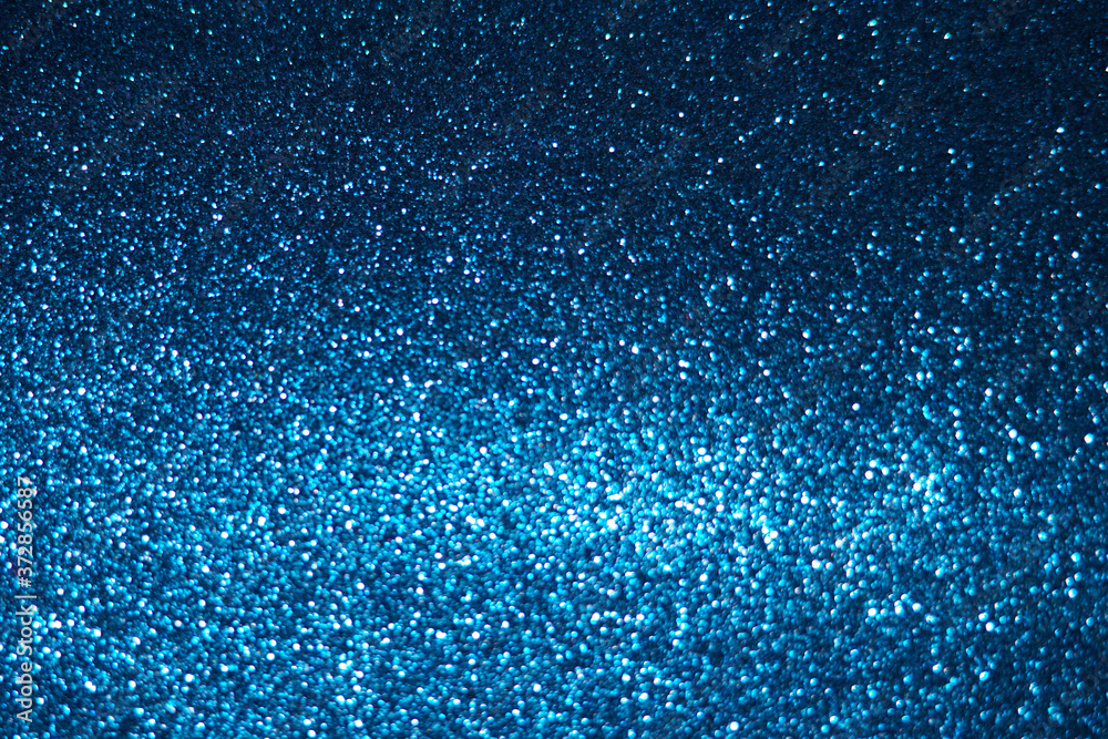 blue Sparkling Lights Festive background with texture. Abstract Christmas twinkled bright bokeh defocused and Falling stars. Winter Card or invitation	