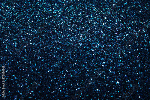 blue Sparkling Lights Festive background with texture. Abstract Christmas twinkled bright bokeh defocused and Falling stars. Winter Card or invitation	