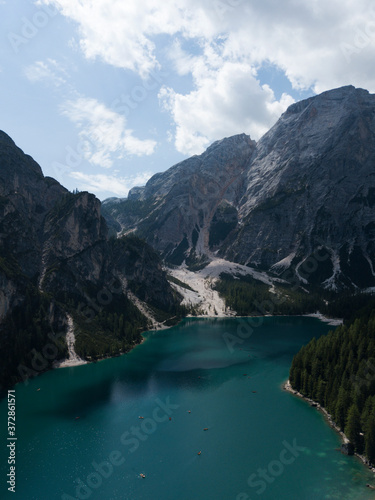 Aerial view of Lago di Braies lake Braies Pragser wildsee in Dolomites mountains Trentino Alto Adige South Tyrol Italy Europe. Braies national park. Boats on emerald water. Spruce forest on highland.