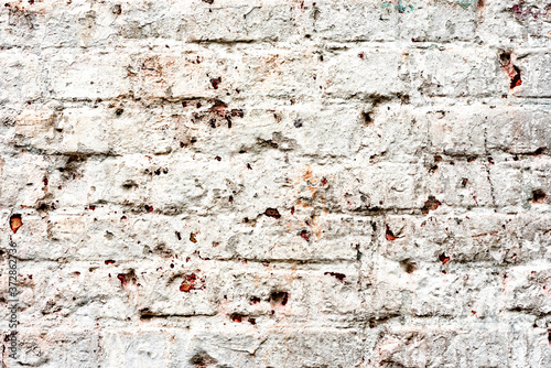 Weathered texture of stained old dark white and orange brick wall background