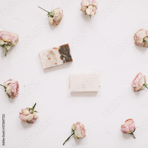 Soap bars with dry roses on white background. Handmade floral soap with rose buds. Natural cosmetics. flat lay, top view