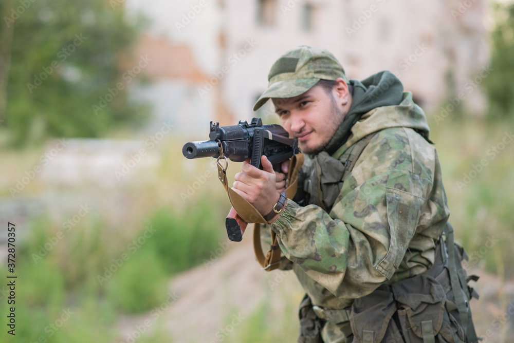 A professional airsoft player aims at his opponents A professional airsoft player aims at his opponents