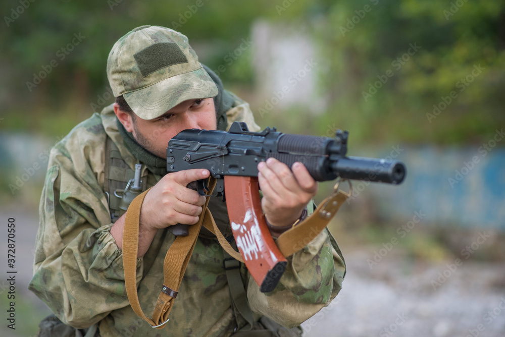 Fototapeta premium A professional airsoft player aims at his opponents