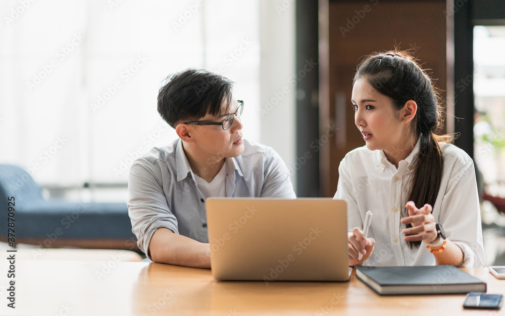 Asian business people man and woman conference talking and working with laptop together. Young couple work at home. Asian business people man and woman conference talking and working with laptop together. Young couple work at home.