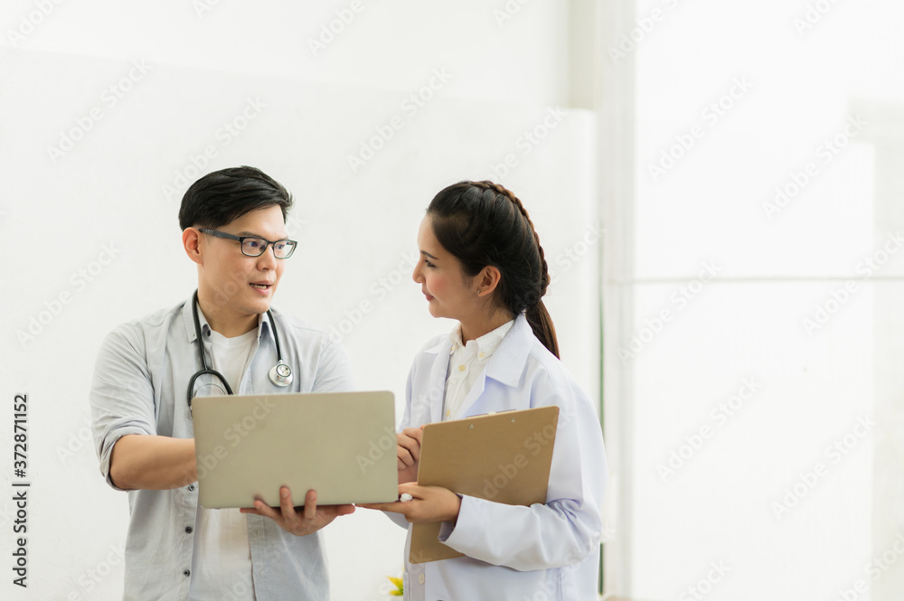 Two professional asian man and woman doctor discussing on laptop to analyse patient person. Two professional asian man and woman doctor discussing on laptop to analyse patient person.
