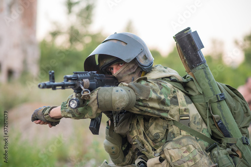A professional airsoft player aims at his opponents photo