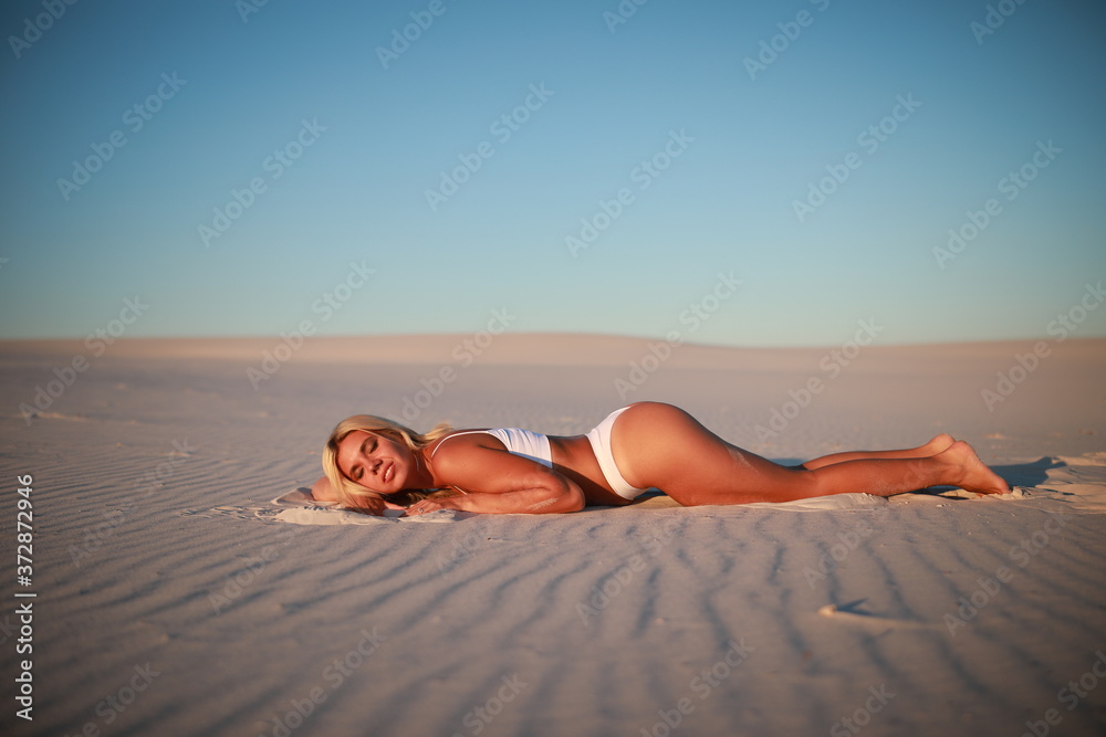 Tanned beautiful girl on white sands
