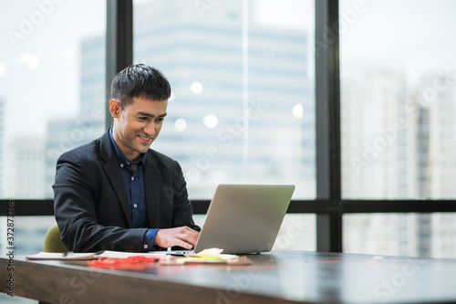 Young asian businessman working with laptop in office.