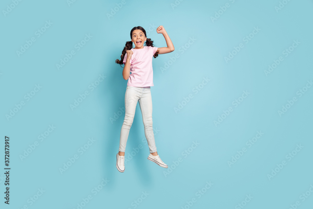 Full length body size view of her she nice attractive pretty overjoyed cheerful cheery lucky girl jumping having fun celebrating rejoicing great news isolated blue pastel color background Full length body size view of her she nice attractive pretty overjoyed cheerful cheery lucky girl jumping having fun celebrating rejoicing great news isolated blue pastel color background