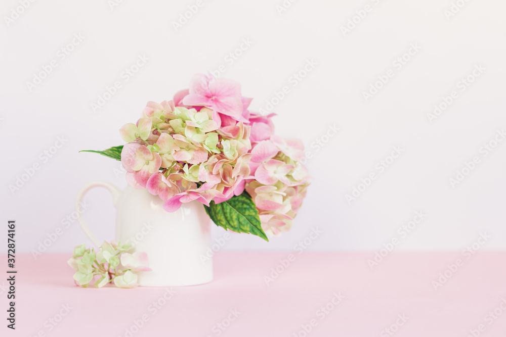 Romantic bouquet of pink Hydrangea flowers in a jar on a pink background. Romantic bouquet of pink Hydrangea flowers in a jar on a pink background.