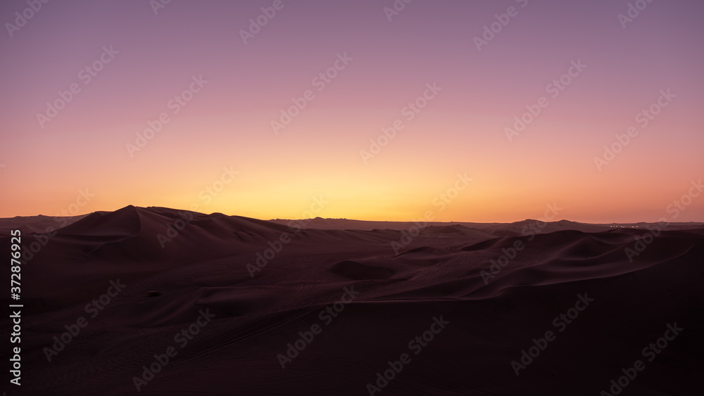 Sunset over desert sand dunes