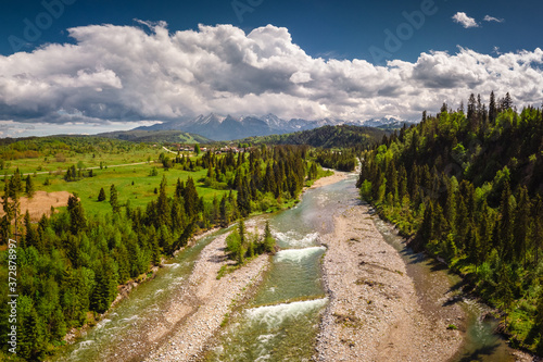 Fototapeta Naklejka Na Ścianę i Meble -  Drone photo of Bialka River with view to the Tatra Mountains- spring season with pretty colours