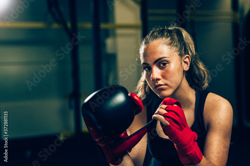 woman kick boxing or boxing training, looking at camera
