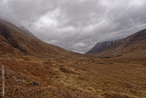 Looking down the Glacial Valley of Glen Etive, with low cloud covering the Mountain Tops with the last remnants of snow clinging to the Slopes